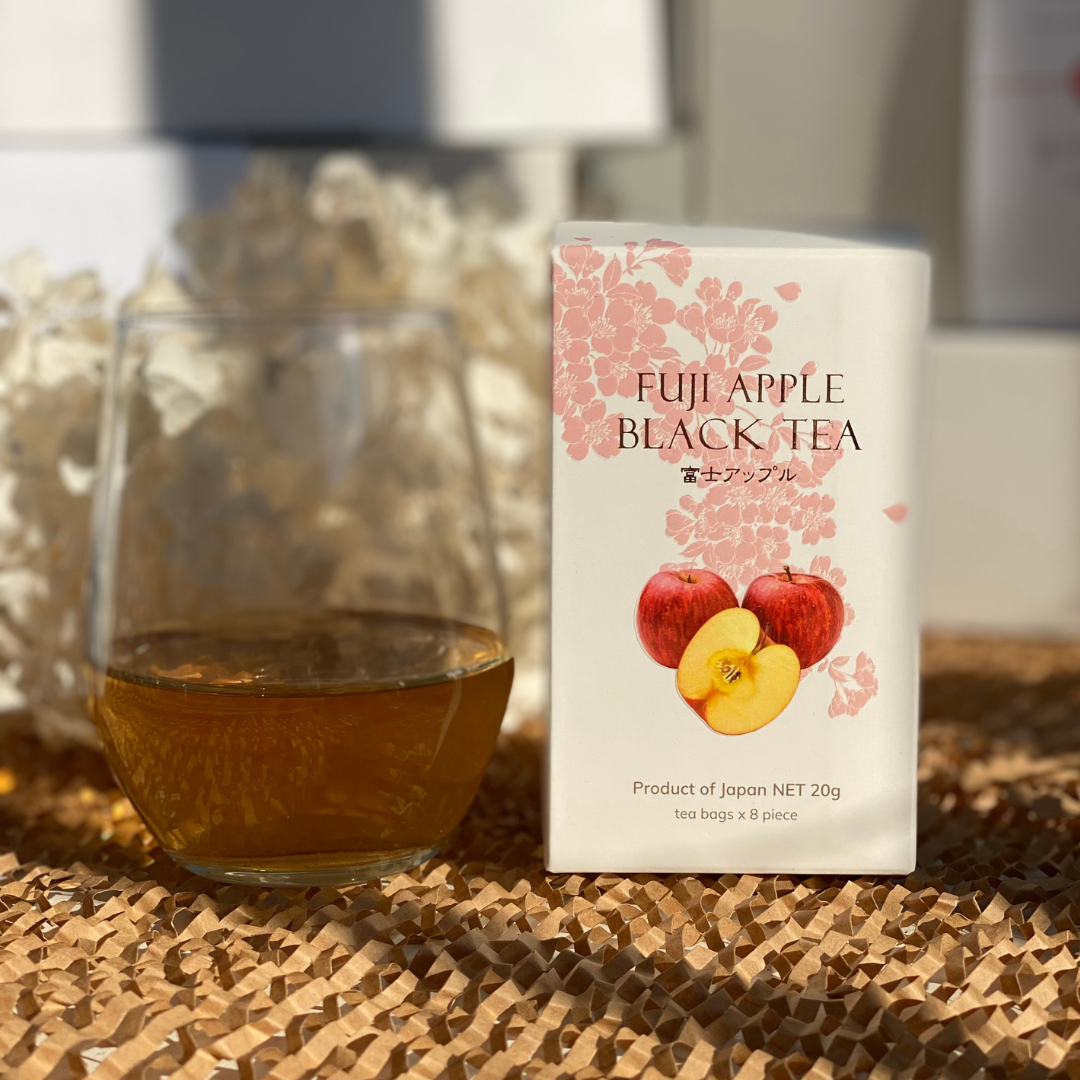 Fuji apple black tea box with a glass of brewed tea.